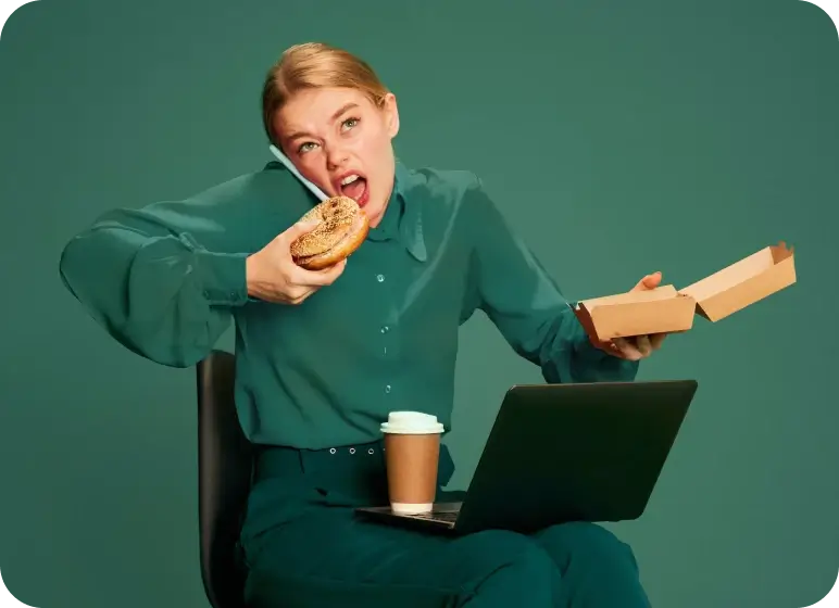 Person multitasking by talking on phone, eating a bagel, and using a laptop, with coffee on lap.