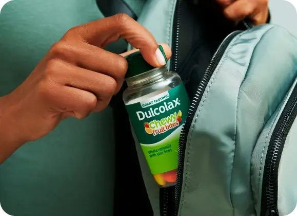 Person placing Dulcolax Chewy Fruit Bites in a backpack.