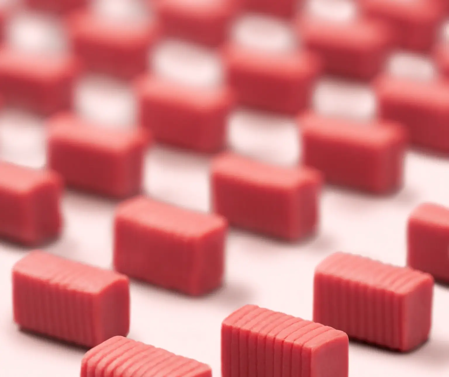 Rows of red, rectangular gums arranged on a surface.